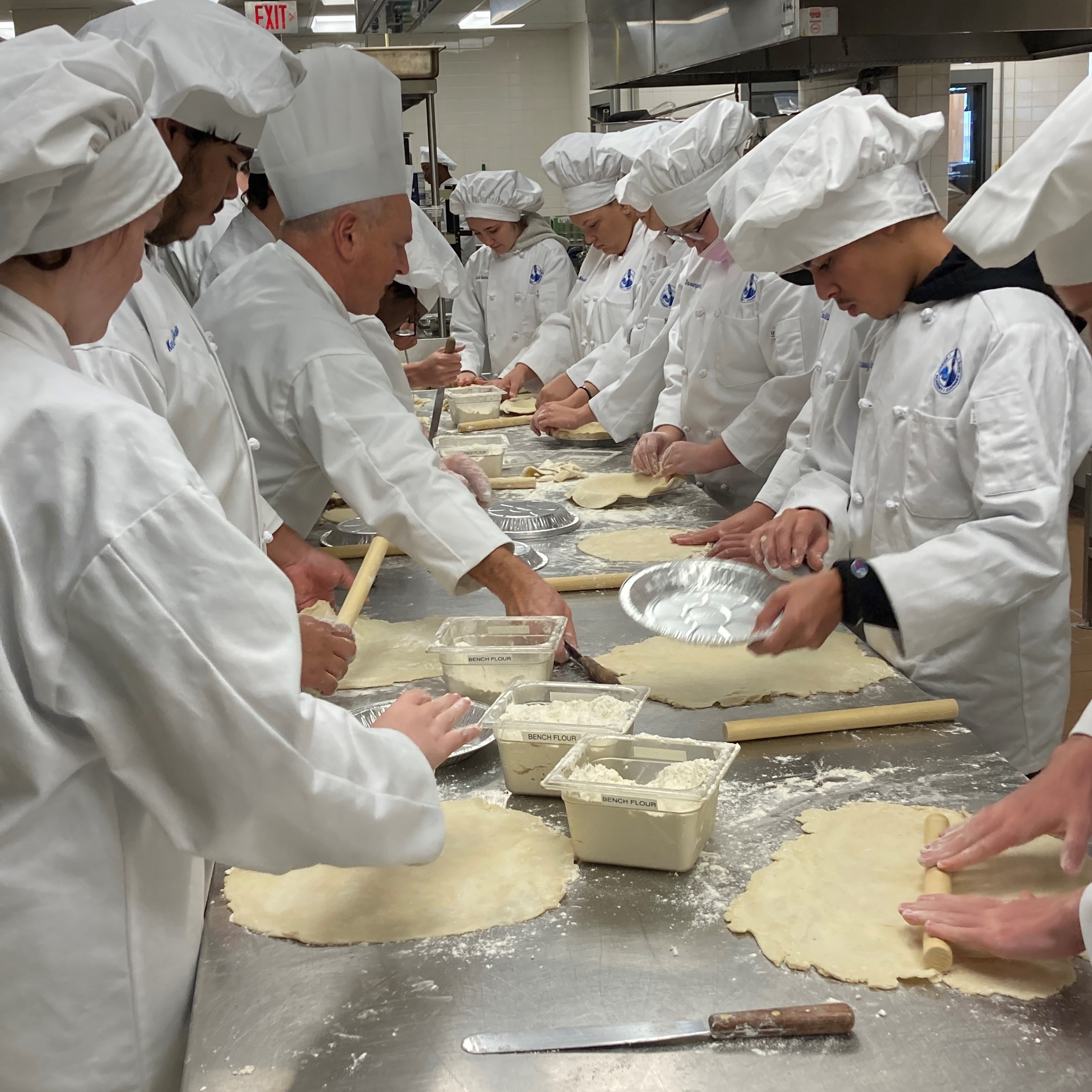 students making pastry for pies in Culinary Arts class under the instruction of their instructor, Chef Glenn Walden