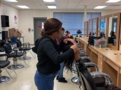 Cosmetology student working in lab with her Mannequin 