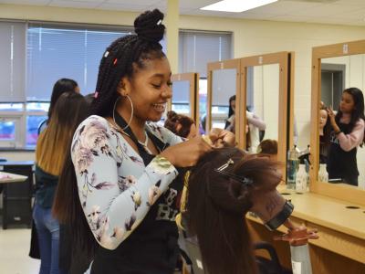 Student demonstrates of braiding in the Cosmetology lab's salon