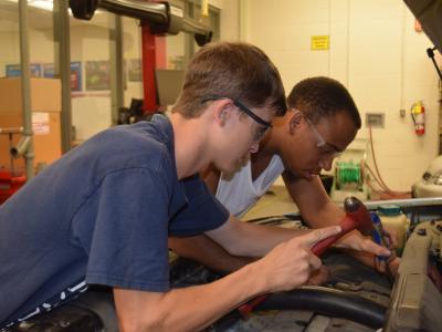 Students working on a car in the Auto Lab