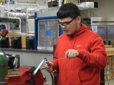 An HVAC student demonstrates brazing and soldering. 