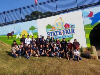 student group in front of state fair logo