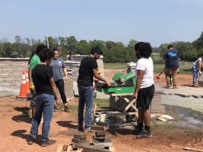 Students cut pavers with wet saw for curved walk installation. 