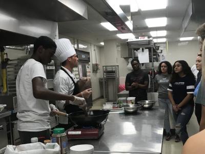  Culinary Level II student volunteer sautes vegetables while Chef Jeff from JWU talks to the group. 