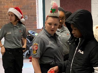 Student volunteers and Police Cadets prepare donated toys for delivery to children.
